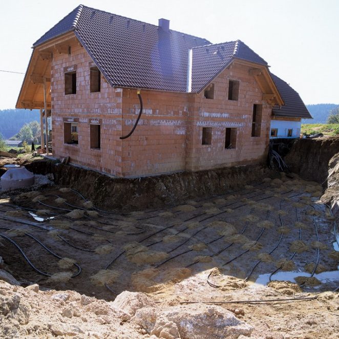 Verlegung eines Flächenkollektors vor einem Haus