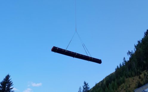 Rohr wird mittels Hubschrauber zur Baustelle in Reisseck transportiert